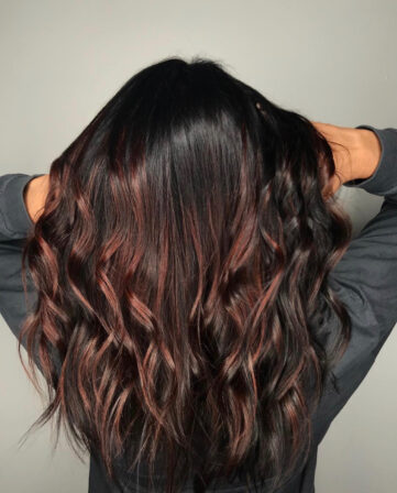 Dark brown hair with copper-red balayage in soft waves, back view