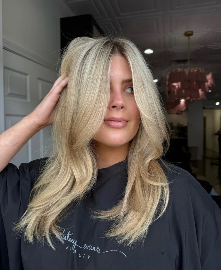 Bright golden blonde hair with long face-framing layers and curtain bangs