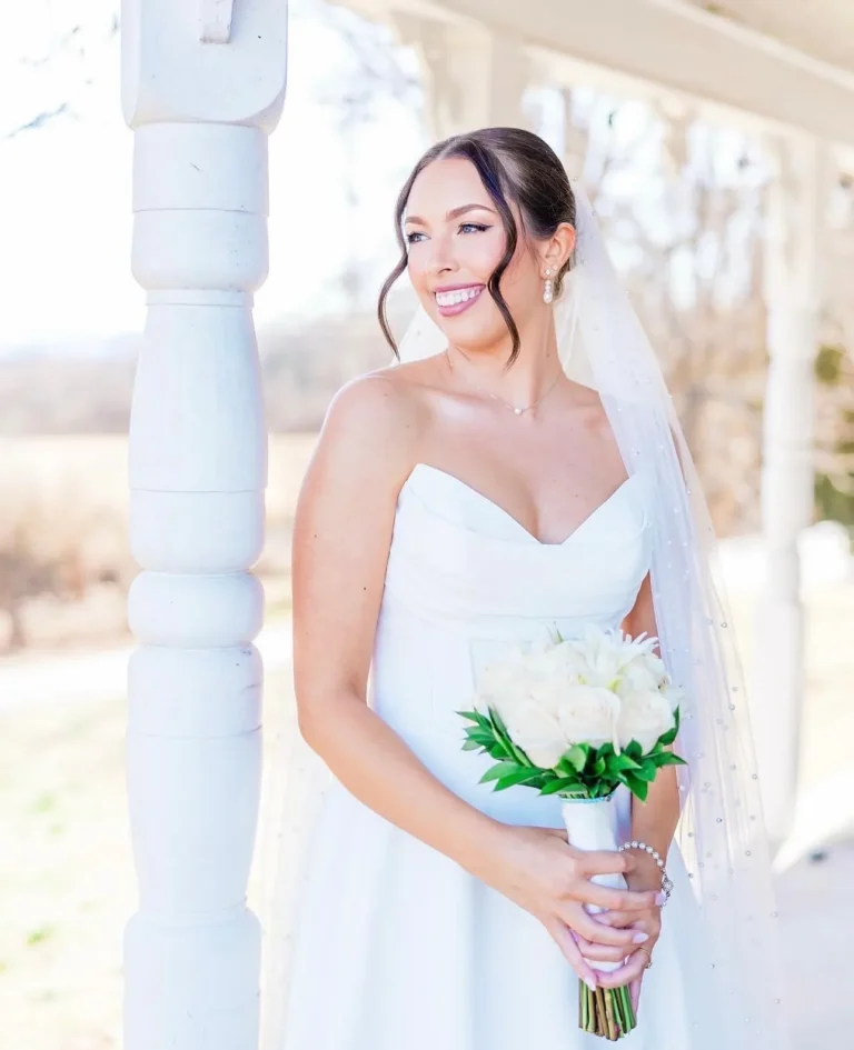 Smiling bride with a soft updo and long veil, wedding hair from a Knoxville salon